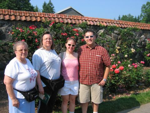 1985 Ford Crown Victoria LTD - A family poses for a photo in front of a blooming rose garden and a stone wall.