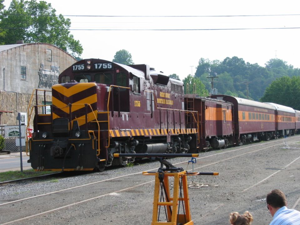 Maroon Great Smoky Mountains Railroad locomotive 1755 with passenger coaches at a depot