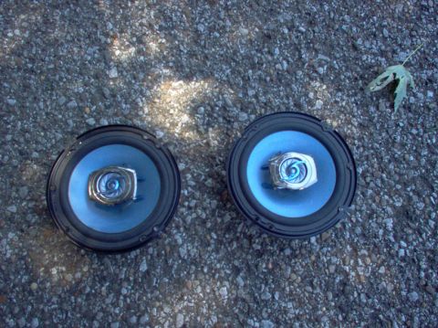 1994 Ford Probe - Two car speakers with blue cones and silver accents are shown on a gravel surface.