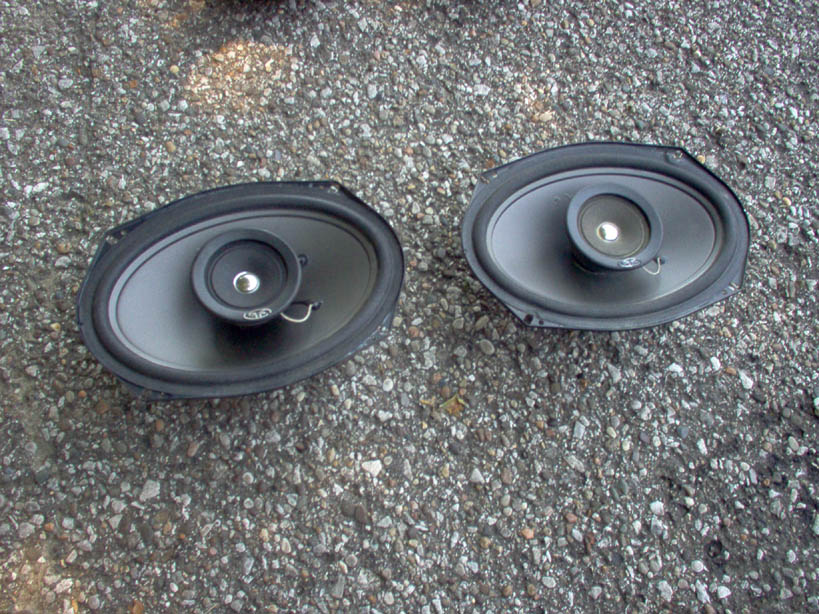 two oval car speakers on gravel