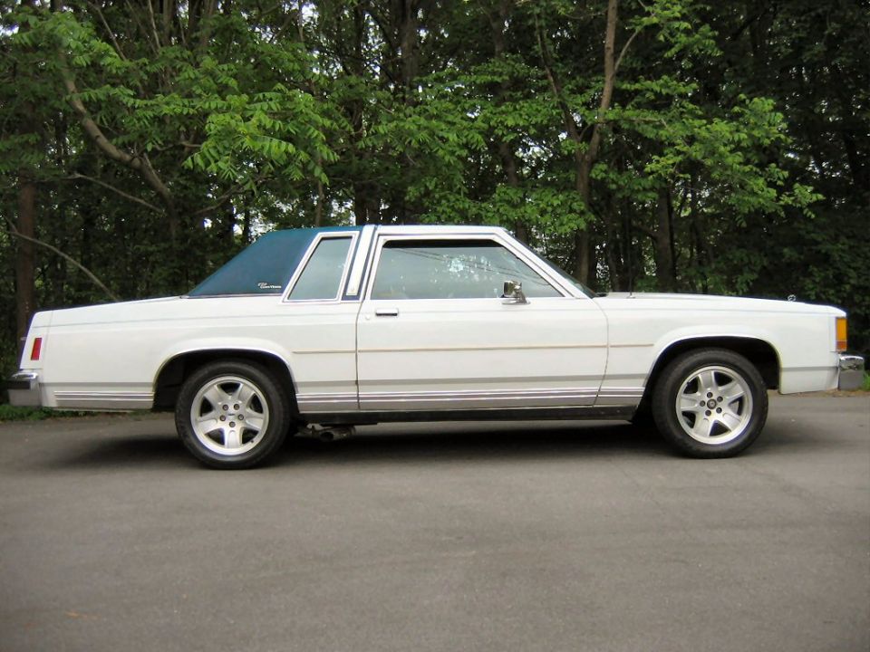 White 1985 Ford Crown Victoria LTD coupe with blue vinyl roof, side view