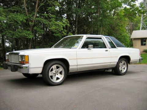 1985 Ford LTD Crown Victoria - This 1985 Ford Crown Victoria LTD is shown from the front 3/4 angle, highlighting its chrome grille and distinctive body style.