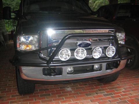 2005 Ford F-250 - Frontal view of a dark gray Ford F-250 truck, equipped with a chrome grille and a black brush guard with auxiliary lights.