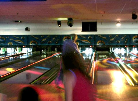 2001 Mercury Grand Marquis - A person is blurred in the foreground of a bowling alley with multiple lanes visible.