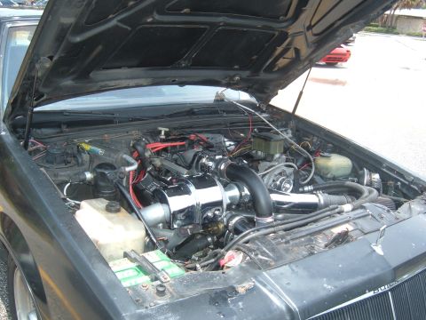 1989 Ford Probe - Customized engine bay a turbocharger, with a second vehicle in the background.