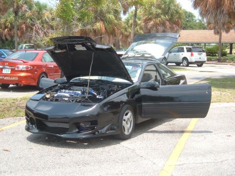 1989 Ford Probe - A black sports coupe is parked with its hood and driver's door open, revealing the engine bay and interior.