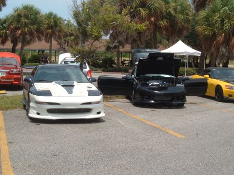 1989 Ford Probe - A modified 1989 Ford Probe is parked in a lot with other vehicles under a sunny sky.