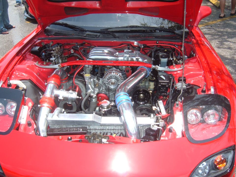 Red car engine bay with twin turbochargers and custom intake piping