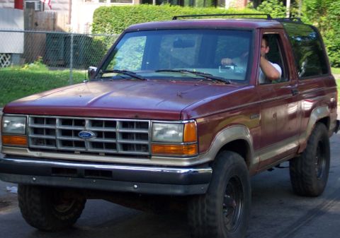1979 Ford F-250 - Maroon Ford Bronco II, likely from the late 1980s, is seen from the front 3/4 angle.