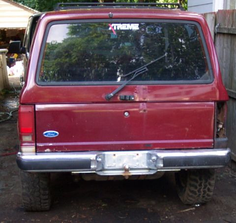 1979 Ford F-250 - Rear view of a red Ford Bronco II, showing its tailgate, bumper, and taillights.