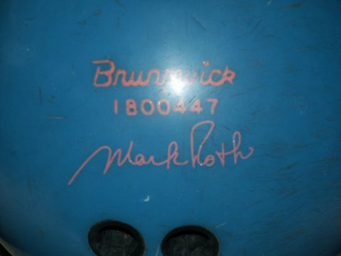 2001 Mercury Grand Marquis - A blue bowling ball with pink lettering that reads 'Brunswick', '1800447', and 'Mark Roth'.