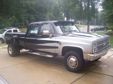 2005 Dodge 1500 - This dually pickup truck has a two-tone paint scheme with silver racing stripes and a black top section.