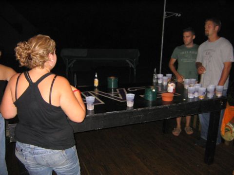 1986 Ford Mustang - Party scene with people playing beer pong at night.