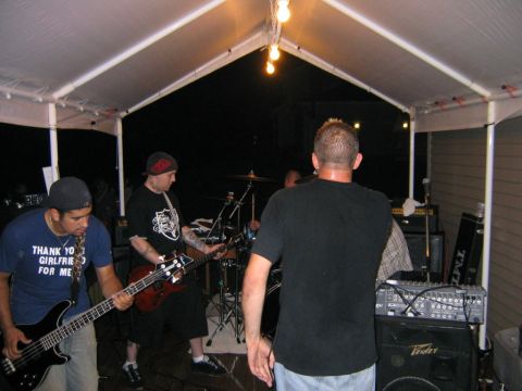 1986 Ford Mustang - A band performs live music under a tent at an outdoor event.