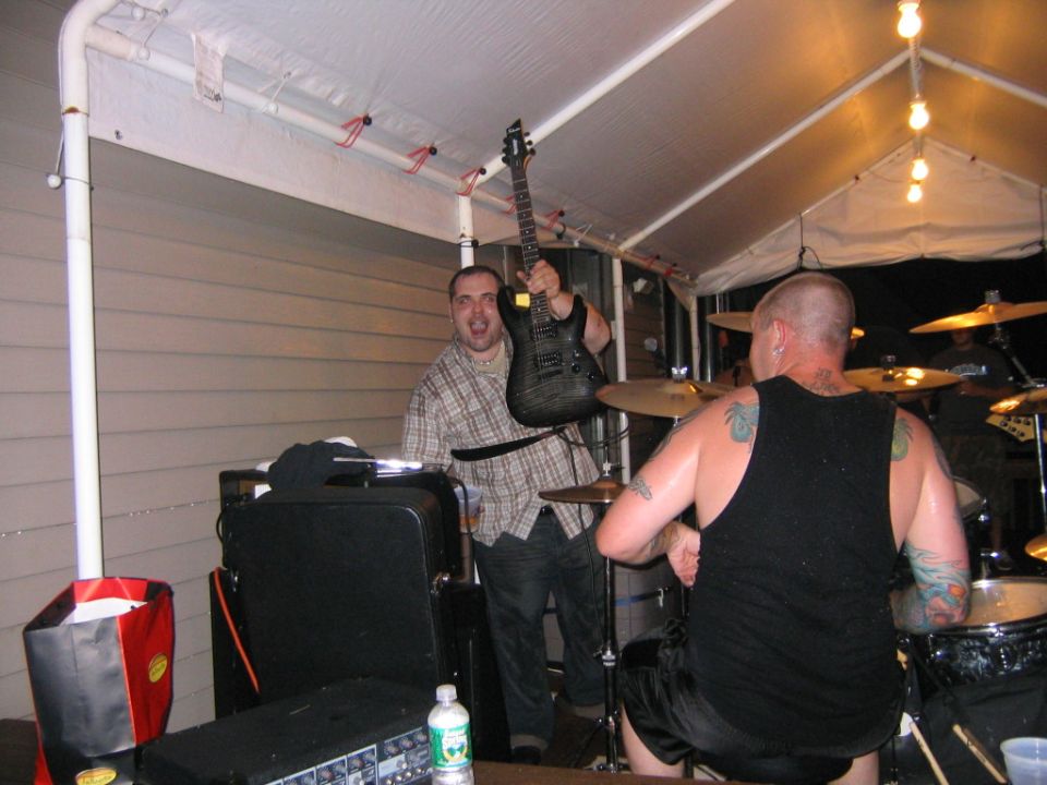 Man holding electric guitar at outdoor party