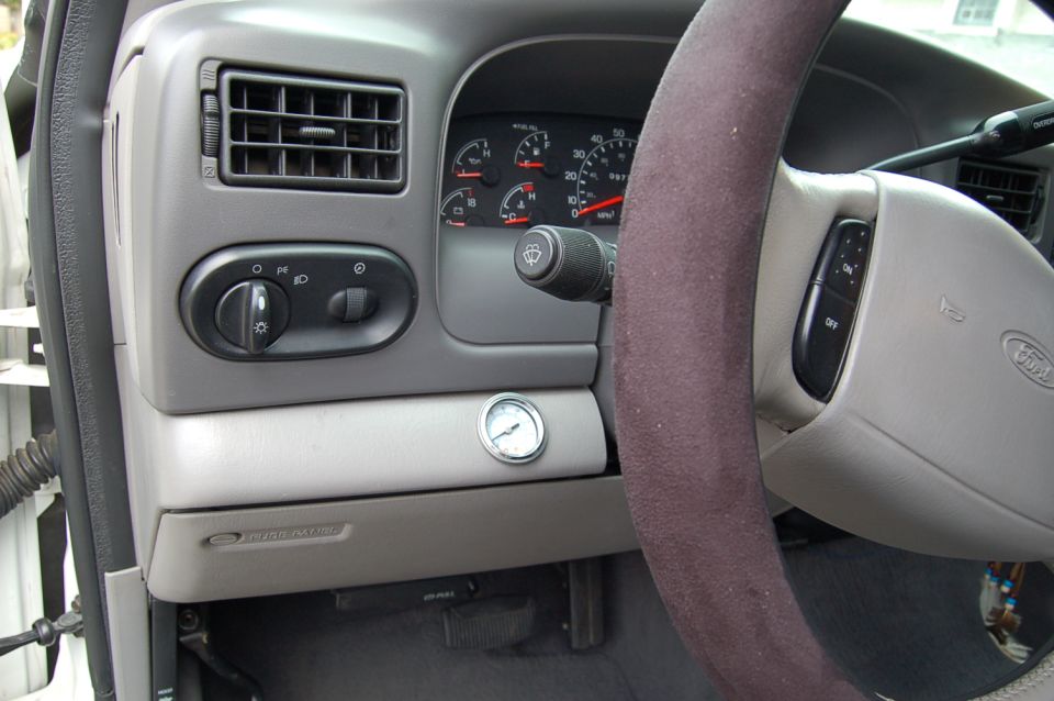 2001 Ford Excursion dashboard with gauges, air vent, light controls, and steering wheel