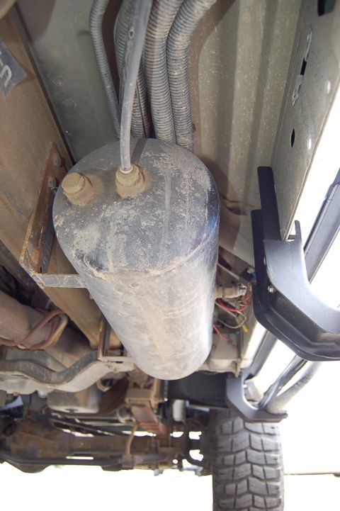 2001 Ford Excursion - This photo shows the undercarriage of a vehicle, focusing on an air tank and associated plumbing.