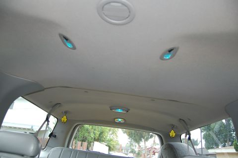 2001 Ford Excursion - The interior ceiling of the vehicle shows multiple dome lights and air vents, with a view of the outside through the rear window.