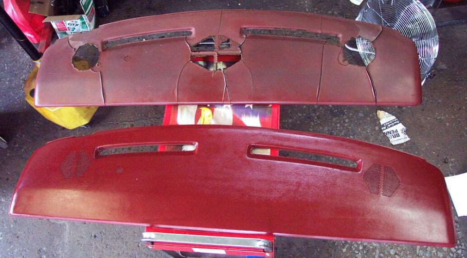 Cracked burgundy dash pad next to an intact replacement dash pad on a shop floor
