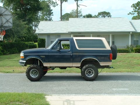 1995 Ford Bronco - Side view of a lifted 1995 Ford Bronco with a spare tire mounted on the rear.