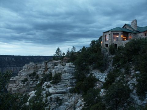 2001 Mercury Grand Marquis - A stone building sits atop a rocky cliff overlooking a vast landscape under a dramatic, cloudy sky.