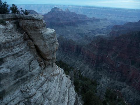 2001 Mercury Grand Marquis - A vast canyon landscape under a twilight sky, with rocky cliffs in the foreground and a distant mountain peak.