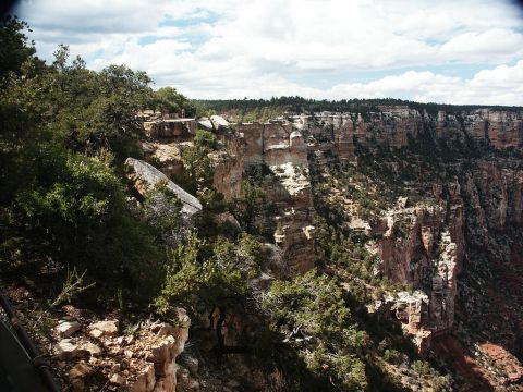 2001 Mercury Grand Marquis - A scenic view of the Grand Canyon, its vastness and geological formations under a partly cloudy sky.