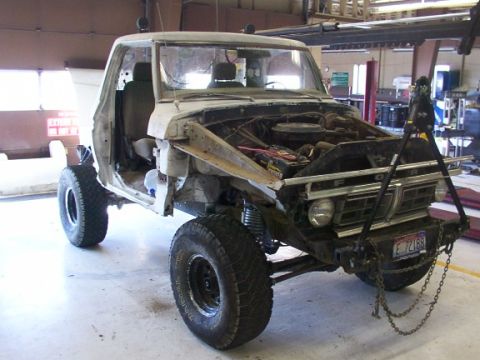 1978 Ford Bronco - This 1973 Ford truck is undergoing repairs in a workshop, showing its engine and chassis.