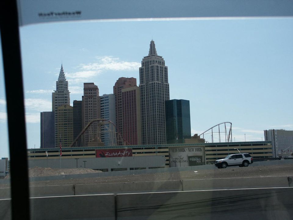 White SUV driving past New York-New York Hotel & Casino