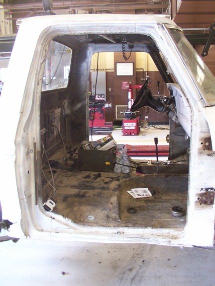 1978 Ford Bronco - The interior of a white pickup truck cab is shown, stripped down and ready for restoration work.