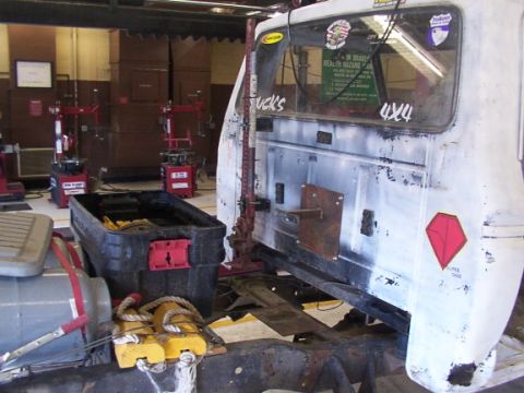 1978 Ford Bronco - A truck cab is being worked on in a garage, with various tools and equipment visible around it.