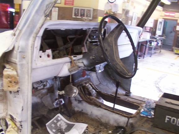 Interior of a disassembled vehicle showing dashboard and steering wheel