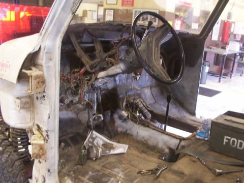 1978 Ford Bronco - Vehicle interior in a state of disassembly, with wiring exposed and the steering wheel in place.