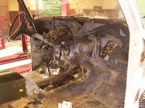 1978 Ford Bronco - The interior of a vehicle is shown disassembled, with exposed wiring and a bare dashboard.