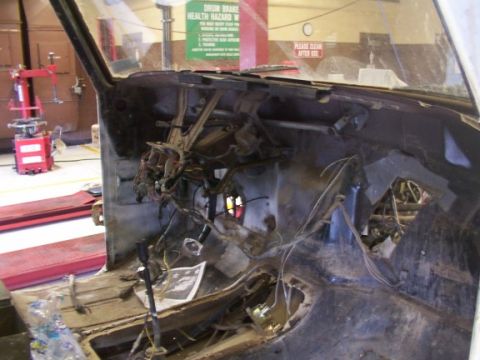 1978 Ford Bronco - The interior of a vehicle is shown with its dashboard removed, revealing a complex network of wires.