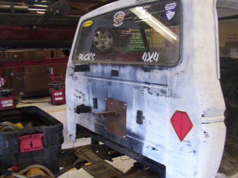 1978 Ford Bronco - The rear of a white vehicle is shown, "BUCKS" and "4x4" stickers and a spare tire visible through the window.