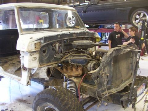 1978 Ford Bronco - Chassis of a Ford truck being worked on, engine visible. Restoration project underway.