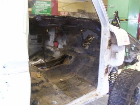 1978 Ford Bronco - The interior of a vehicle is shown with its dashboard and floor removed, indicating ongoing restoration or modification.