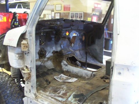 1978 Ford Bronco - The interior of a vehicle is shown with the dashboard removed and significant rust on the floor, indicating a restoration project.