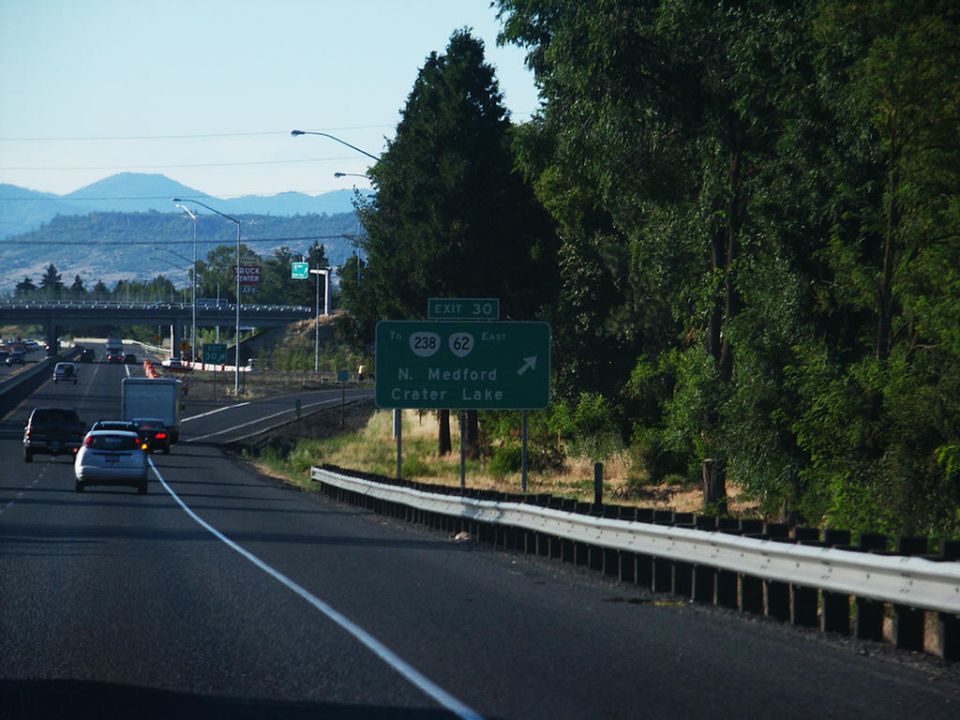 Highway scene with traffic, trees, and a sign for Exit 30, N. Medford, Crater Lake