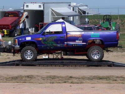 1972 Ford Ranchero - A custom purple pickup truck with a dragon graphic and "Sled Draggin" text is weighed on a scale, with other vehicles and trailers in the b…