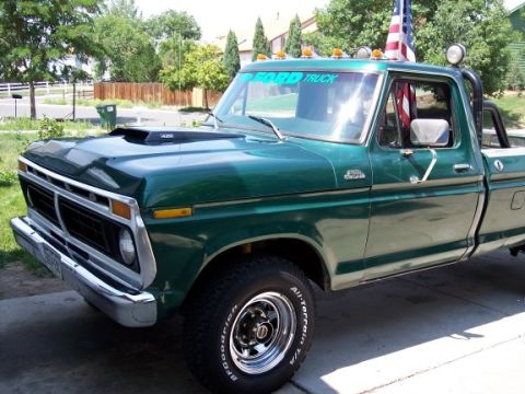 1972 Ford Ranchero - This green Ford pickup truck features a hood scoop and an American flag mounted on the roof.