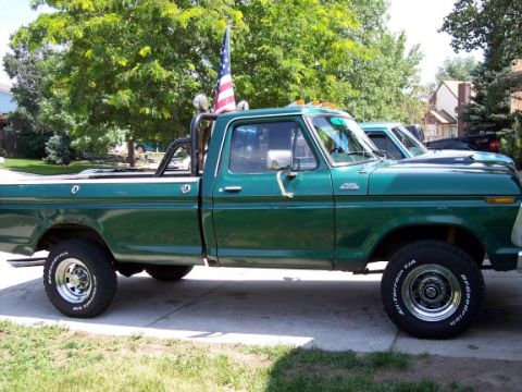 1972 Ford Ranchero - Side view of a green 1977 Ford F-150 pickup truck with an American flag.