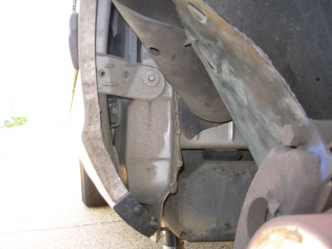 1994 Ford Crown Victoria - Peel the wheelwell forward to expose the gold T-20 Torx screw, and remove it.