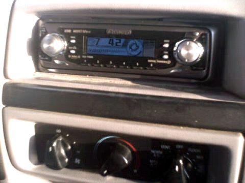 1996 Ford Bronco - The interior of a vehicle shows a Kenwood stereo unit and climate control knobs.