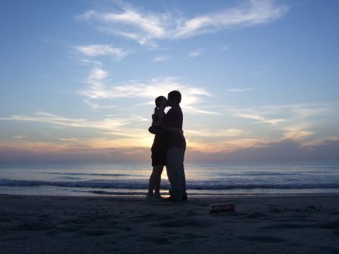 1994 Ford Probe - Romantic sunset scene on the beach with a couple embracing.