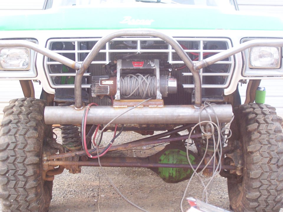 Close front-end view of lifted Ford 4x4 showing winch behind tube bumper and front axle wiring
