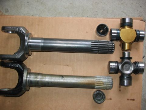 1995 Ford Bronco - Two driveshaft yokes and two U-joints are shown, with one U-joint a gold-colored cap.