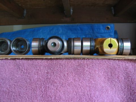 1995 Ford Bronco - Close-up of automotive driveshaft components, including universal joints and yokes, resting on a pink towel.