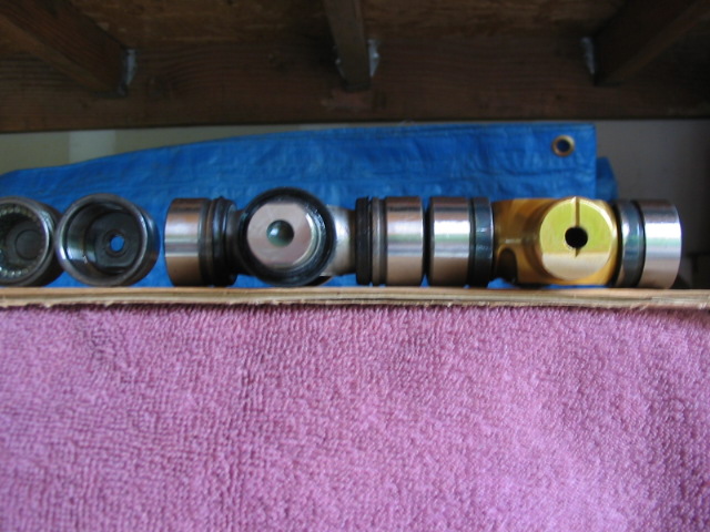 Disassembled metal shaft and seals from a vehicle component on a pink towel